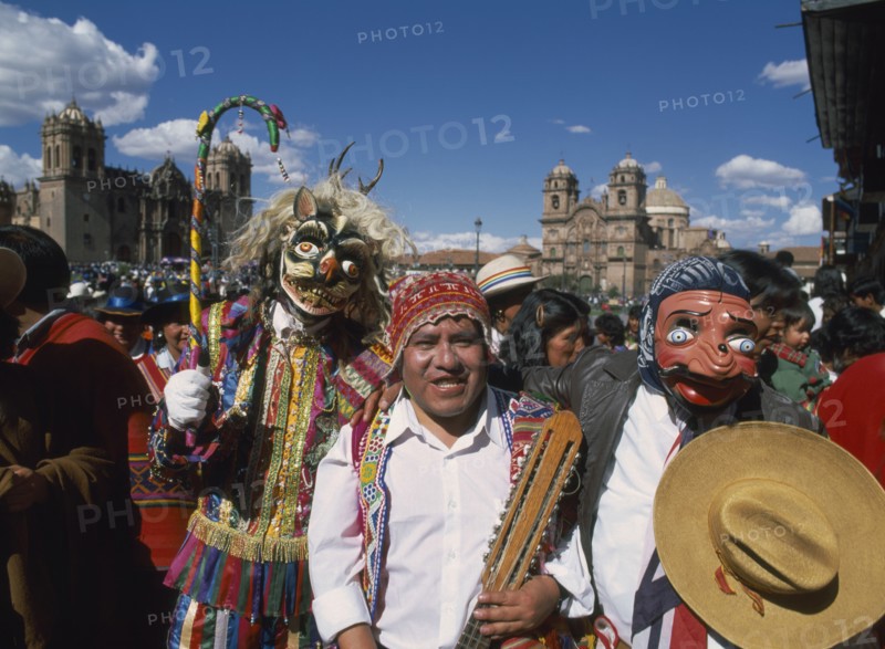 PERU, Cusco Department, Cusco, "Group of musicians and masked dancers in traditional costume at Inti Raymi.  Three quarter view, facing the camera."