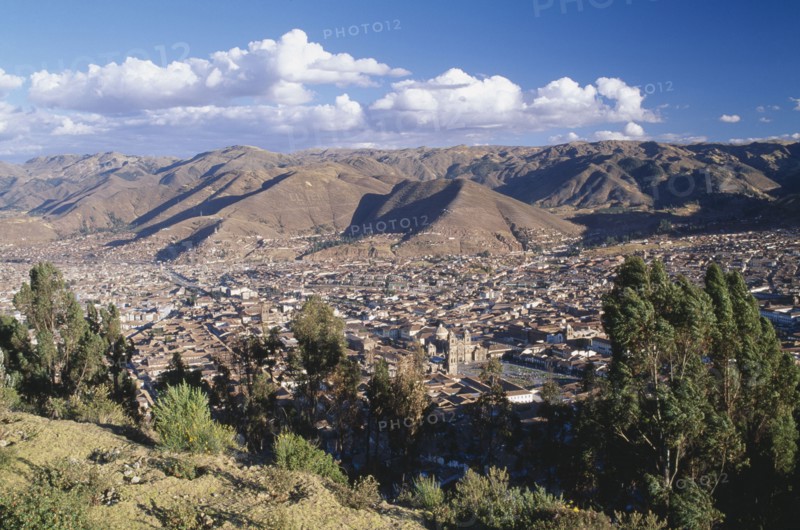 PERU, Cusco Department, Cusco, View over trees and the city of Cusco to the mountains beyond.