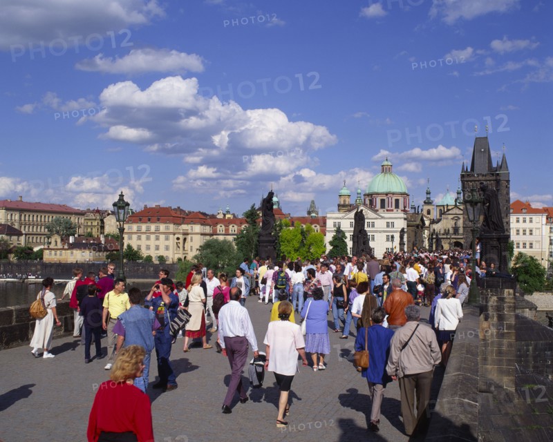 CZECH REPUBLIC, Stredocesky , Prague, Mala Strana.  Crowds of people crossing Charles Bridge.  Typical houses in the background.