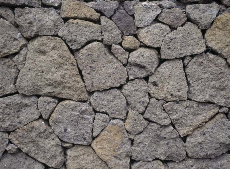 INDONESIA, Bali, Lovina, Detail of dry stone wall at Kalibukbuk