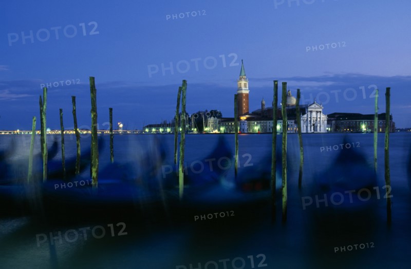ITALY, Veneto, Venice, Line of gondolas in motion with the Church of San Giorgio behind.