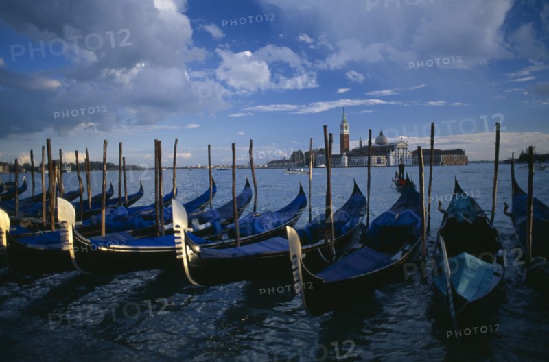 ITALY, Veneto, Venice, Line of gondolas with the Church of San Giorgio behind.