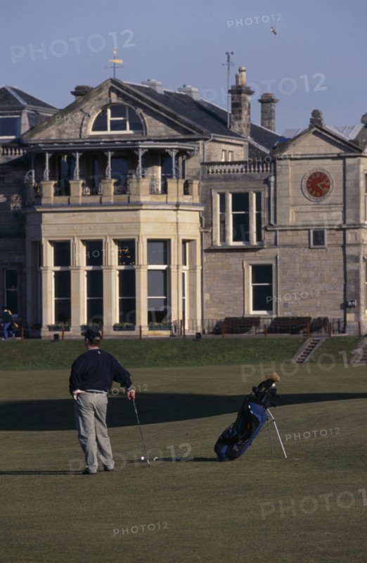 20006178 SPORT Ball Games Golf Golfer standing on green outside St. Andrews golf course clubhouse