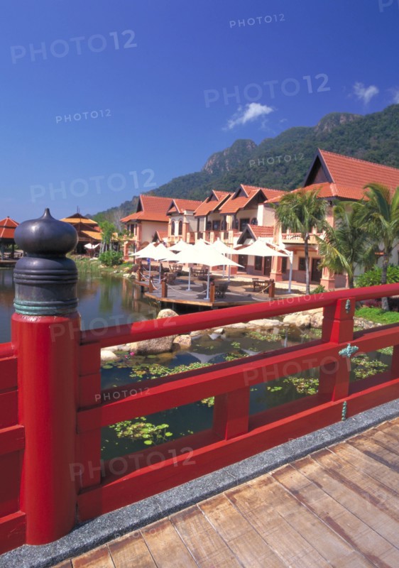 MALAYSIA, Kedah, Langkawi, Oriental Village shopping complex at Burau Bay set around an artificial lake with Gunung Mat Cincang behind