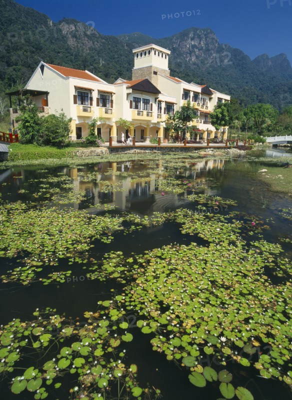 MALAYSIA, Kedah, Langkawi, Oriental Village shopping complex at Burau Bay set around an artificial lake with Gunung Mat Cincang behind