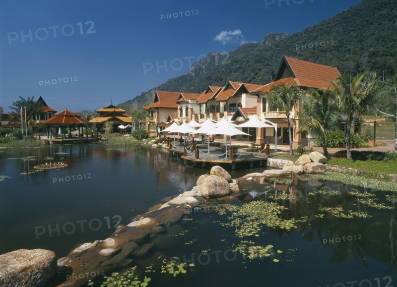 MALAYSIA, Kedah, Langkawi, Oriental Village shopping complex at Burau Bay set around an artificial lake with Gunung Mat Cincang behind
