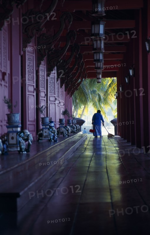 MALAYSIA, Kedah, Langkawi, The Summer Palace on Pantai Kok beach with woman sweeping the floor of the main pavilion film set for Anna And The King