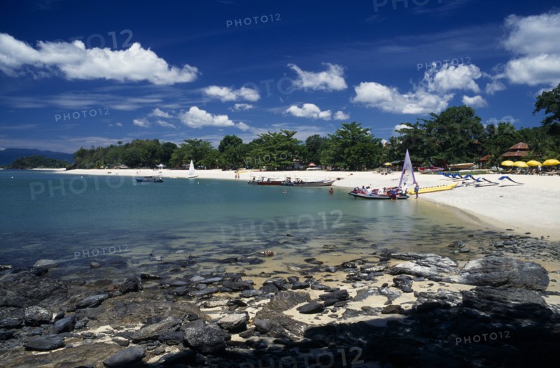 MALAYSIA, Kedah, Langkawi, Pantai Tengah beach at the south end by The Lanai hotel with tourist boats at the water’s edge