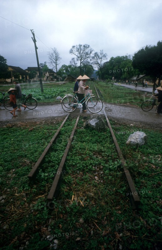 VIETNAM, Lang Son, People with bicycles crossing a disused railtrack near the Chinese border.