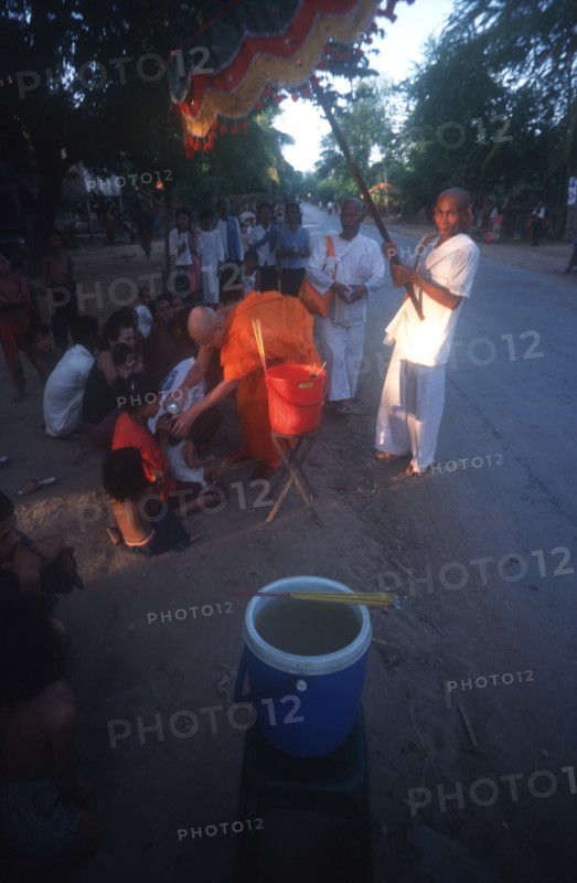 CAMBODIA, Saang, Buddhist monk blessing a child at the roadside.
