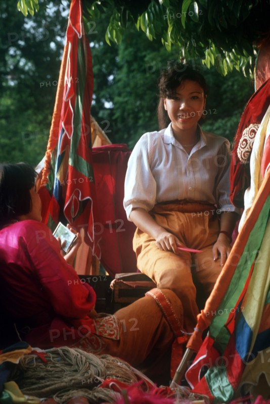 VIETNAM, Market, Woman selling brightly coloured fabrics and cloth.