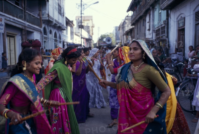 INDIA, Gujarat, Bhavnagar, Hindu wedding with women doing a traditional dance with sticks in the street