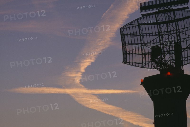 TRANSPORT, Air, Airport, Radar scanner in the foreground  at London Heathrow with vapour trails in the sky in the shape of an aeroplane