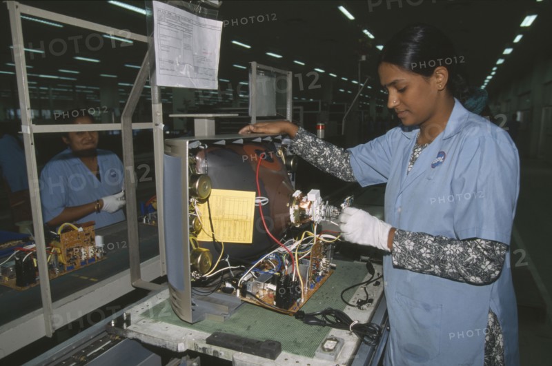 INDIA, Karnataka, Bangalore, Woman in factory making electrical components for televisions.