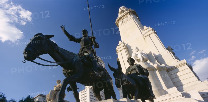 SPAIN, Madrid State, Madrid, "Plaza de Espana.  Angled view of the statues of Miguel de Cervantes with Don Quixote on his horse and Sancho Panza on a donkey  in the foreground, seen from below."