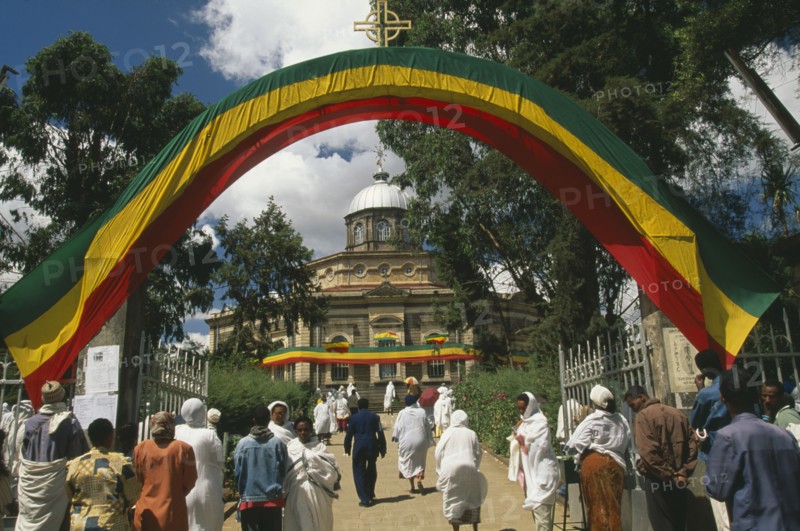 ETHIOPIA, Addis Ababa, "St George Church, Kidus Giorgis, the principle church in Addis Ababa.  People entering grounds under archway draped in the colours of the national flag to attend ceremony."