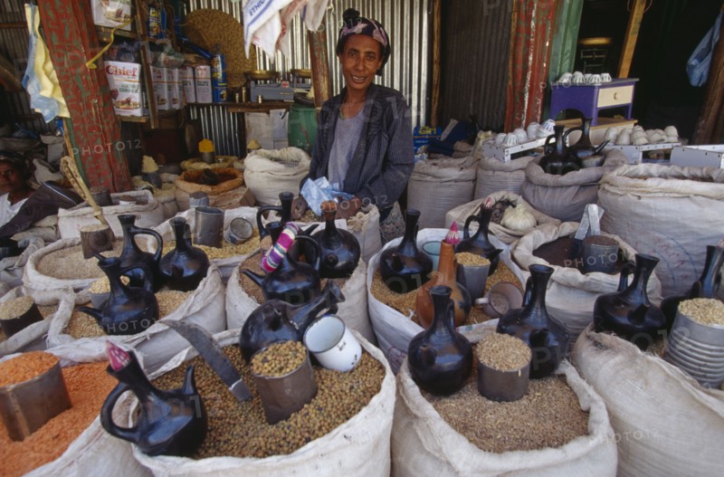 ETHIOPIA, Gojam Province, Markets, Female vendor behind display of sacks of cereals and pulses for sale at a market.