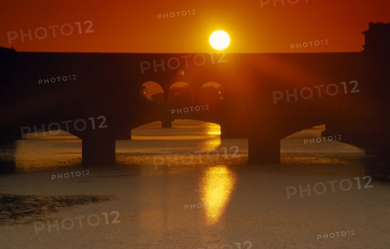 ITALY, Veneto, Florence, Bridge silhouetted against deep red and orange sunset sky seen from Piazzale Michelangelo.