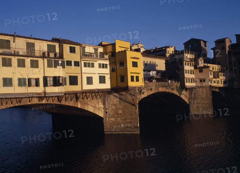 ITALY, Tuscany, Florence, "Ponte Vecchio, the west side in warm, golden light with people standing on central section.  "