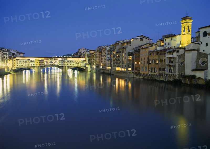 ITALY, Tuscany, Florence, View towards the Ponte Vecchio and waterside buildings at night with lights reflected in the River Arno.