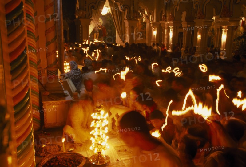 INDIA, Utter Pradesh, Vrindaven, "Dirwali festival, crowds of worshippers holding candles with light trails in dark temple interior.  "