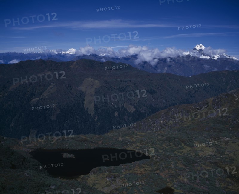 BHUTAN, Simkota Tsho, "View from above towards mountain peak of Jitchu Drakey 6989 metres above sea level, in drifting cloud."