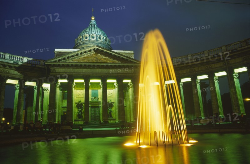 RUSSIA, St. Petersburg, "Kazan Cathedral, exterior facade and fountain in foreground illuminated at night."