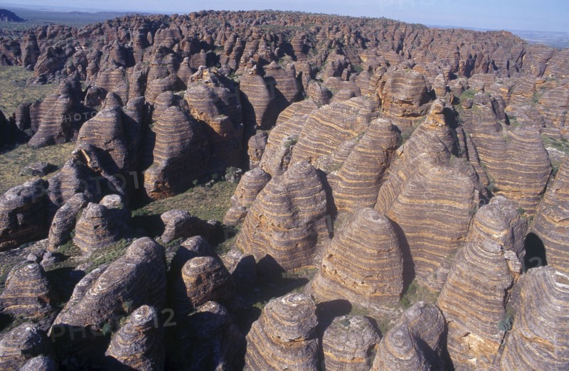 AUSTRALIA, Western Australia, Bungle Bungles, View over rounded rock towers striped in alternate bands of orange silica and black lichen.
