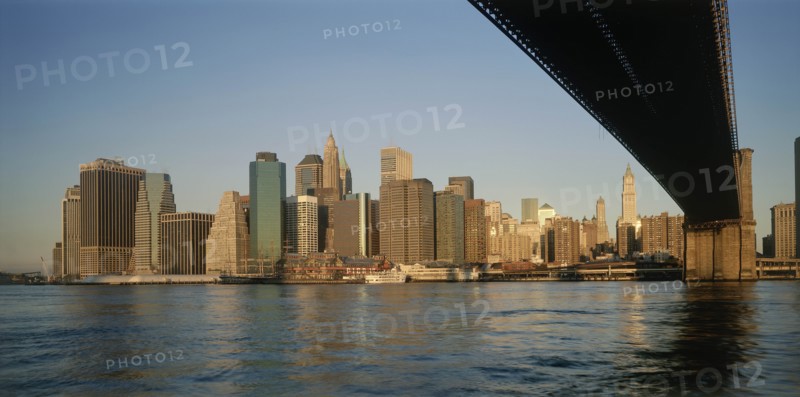 USA, New York State, New York, "Lower Manhattan.  Post September 11 skyline from Brooklyn in warm, golden light with underside of bridge in the foreground."
