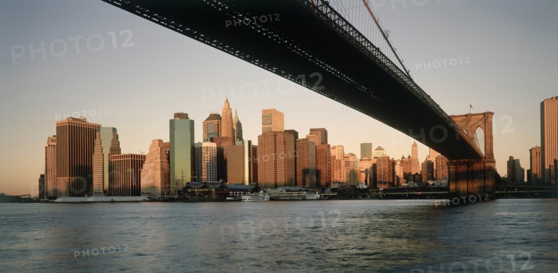 USA, New York State, New York, Lower Manhattan.  Post September 11 skyline from Brooklyn in evening light with underside of Brooklyn         Bridge in the foreground.