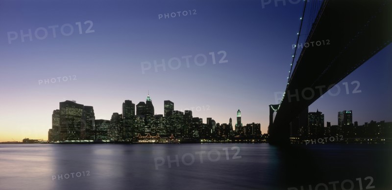 USA, New York State, New York, Lower Manhattan.  Post September 11 skyline from Brooklyn illuminated at night with Brooklyn Bridge in the foreground.
