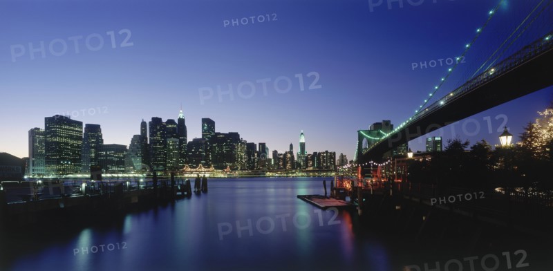 USA, New York State, New York, Lower Manhattan.  Post September 11 skyline from Brooklyn illuminated at night with Brooklyn Bridge in the foreground.