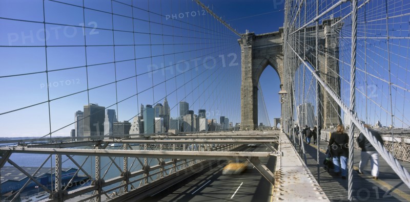 USA, New York State, New York, Lower Manhattan.  Post September 11 skyline from Brooklyn Bridge intersected by tension wires with traffic and pedestrians crossing.