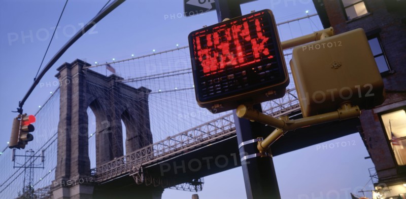 USA, New York, Manhattan, Part view of Brooklyn Bridge at dusk with traffic lights displaying Dont Walk sign in the foreground.