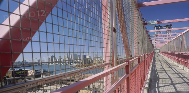 USA, New York State, New York, Williamsburg Bridge.  View along footbridge lined by high sided metal barriers towards city skyline.