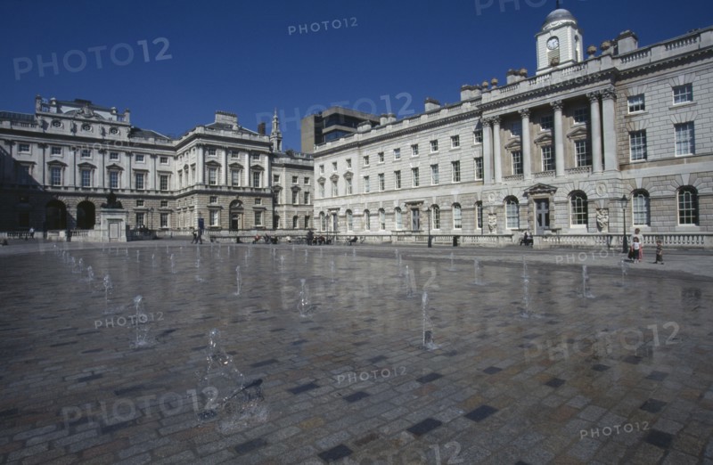 ENGLAND, London, Somerset House and courtyard with rows of small fountains spouting from the ground with onlookers and visitors in the distance.