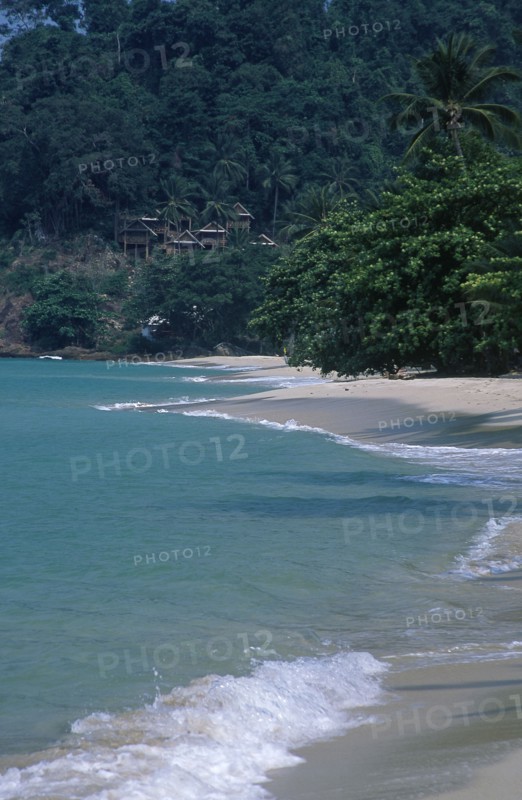 THAILAND, Trat Province, Koh Chang, Chalets on a hillside at the northern end of Aow Bai Lan Lonely Beach with surf rolling onto the beach