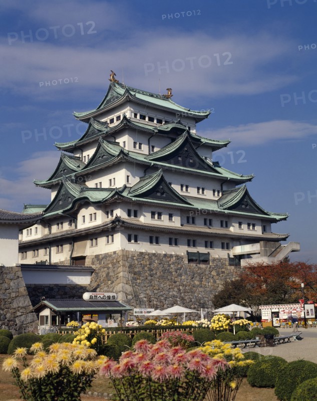 JAPAN, Honshu, Nagoya, The Castle with floral gardens in the foreground and small cabin with tables and chairs outside.