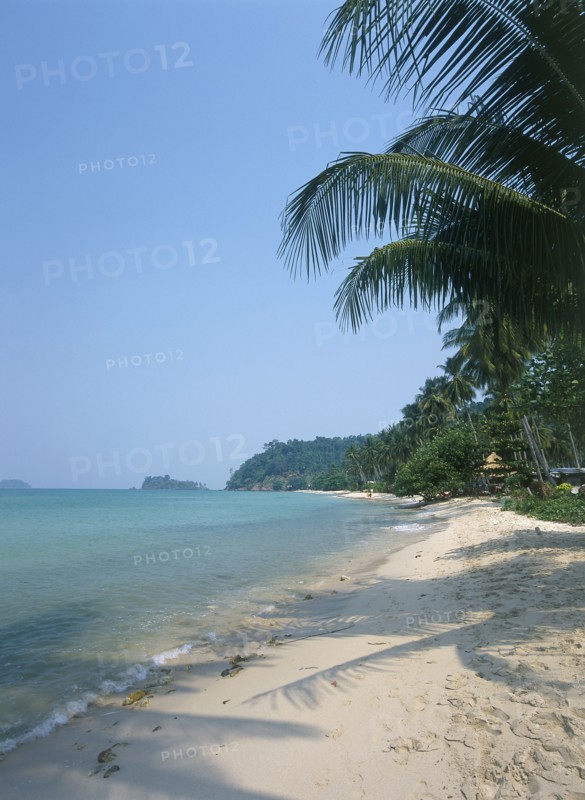 THAILAND, Trat Province, Koh Chang, "Lonley Beach, Aow Bai Lan. View along the sandy bay with palm trees concealing a small hut and small islands in the distance."