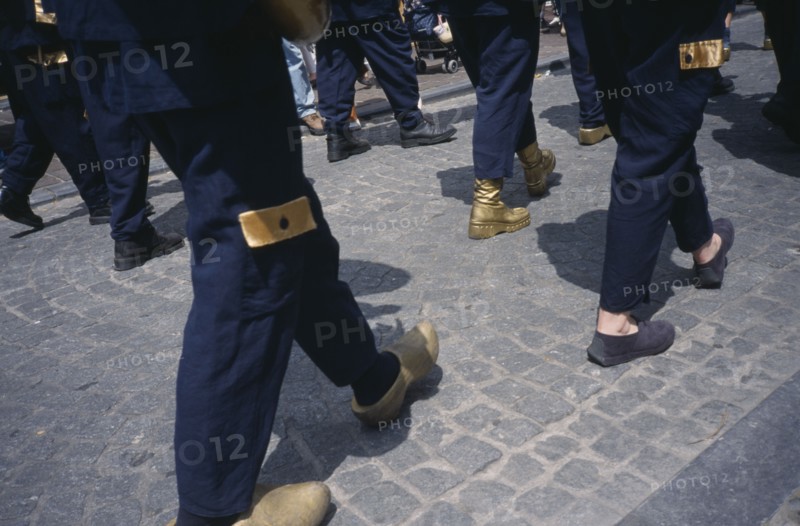 BELGIUM, West Flanders, Bruges, Parade of people wearing golden Clogs in Steenstraat during Braderie festival