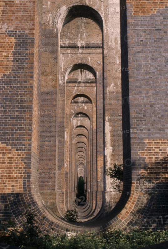 ENGLAND, West Sussex, Haywards Heath, Balcombe. View through line of arches under railway viaduct.