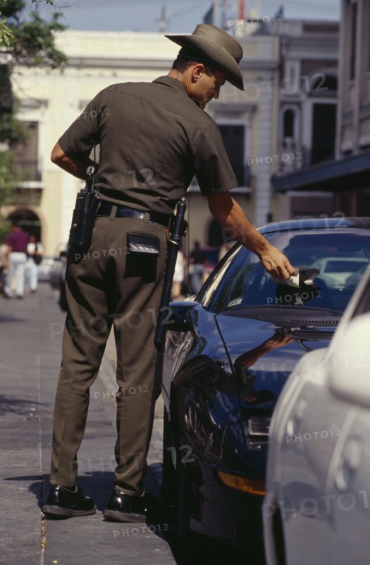 WEST INDIES, Puerto Rico, San Juan, Traffic policeman issuing parking ticket.