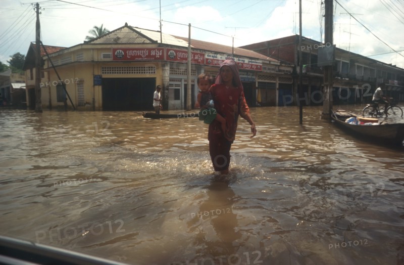 CLIMATE, Weather, Flood, Woman holding young child whilst wading through flooded street