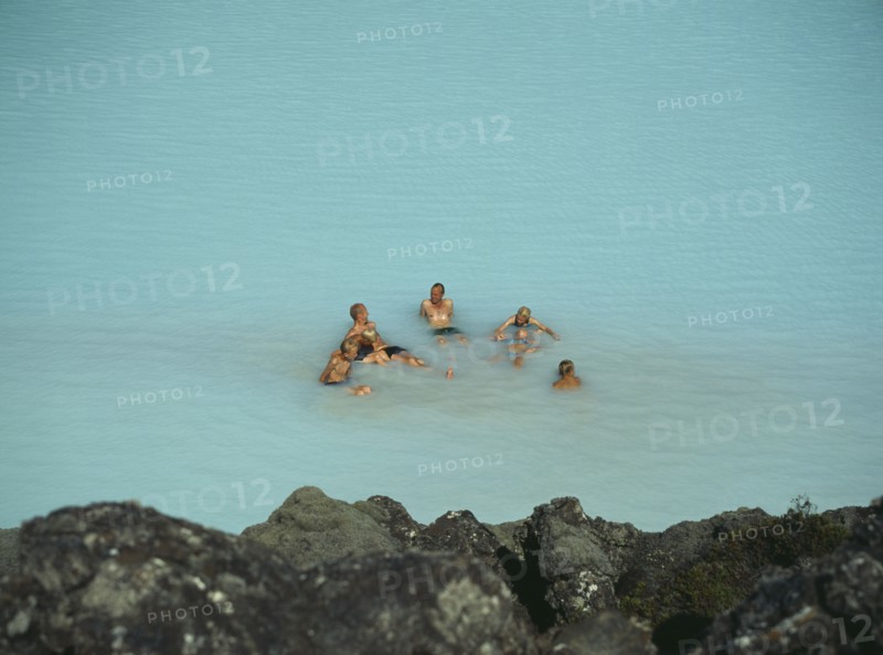 ICELAND, Near Grindavik, Blue Lagoon, Bathers sitting in the hot water rich in natural minerals.