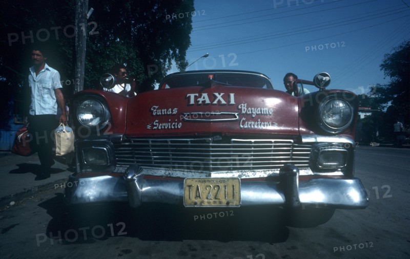CUBA, Granma Province, Bayamo, Red 1950 s Cadillac taxi parked by the kerb