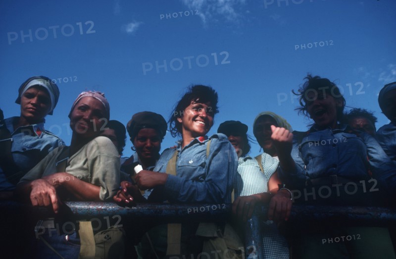 CUBA, Military, Female militia looking over the side of a truck and laughing