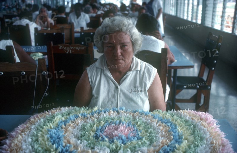 CUBA, Institue of Psychiatry, Female inmate sitting at a table in front of floral design