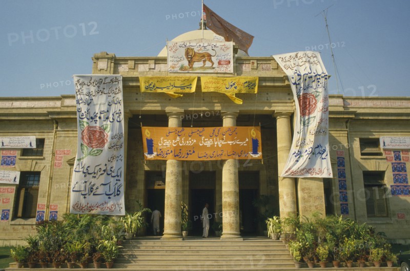 PAKISTAN, Sind , Karachi, Political posters hanging outside columned building entrance