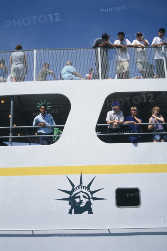 USA, New York, New York City, Circle Line ferry to Liberty Island with passengers leaning over the sides
