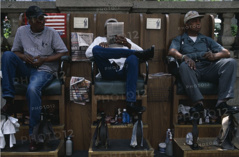 USA, New York, New York City, Shoe shiners relaxing in their chairs